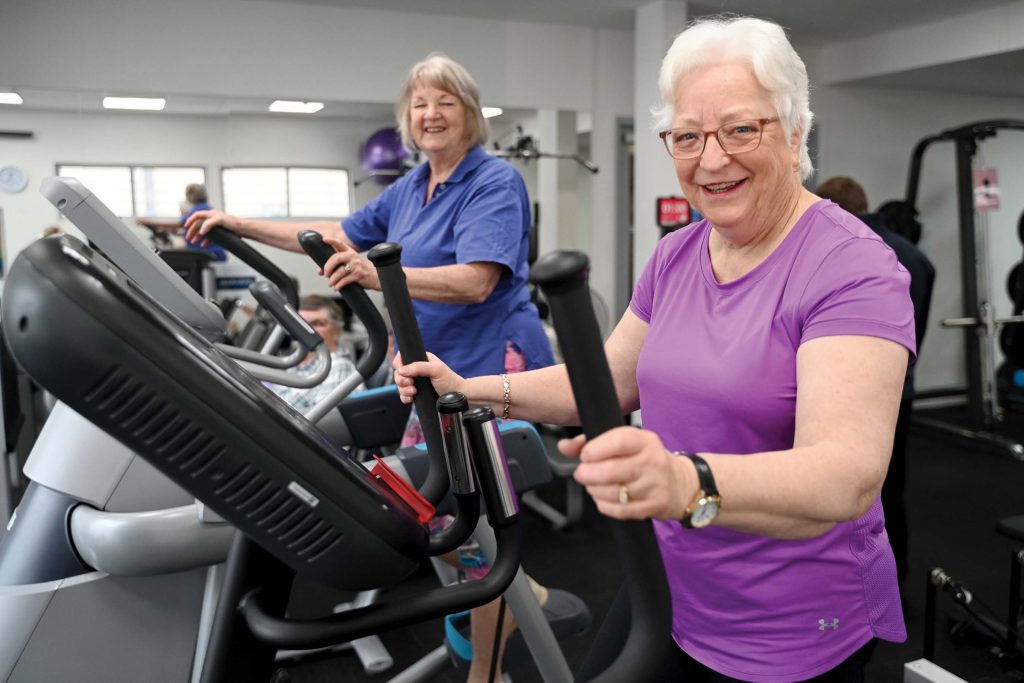 Two women using gym equipment