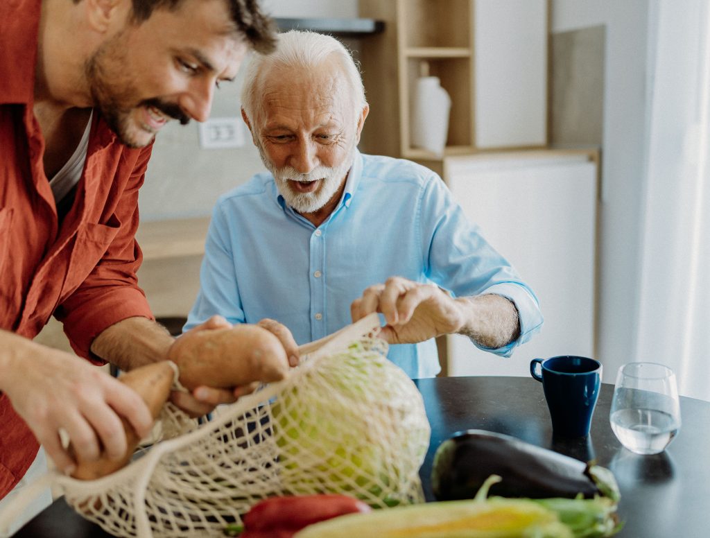 Man helping elderly man with groceries