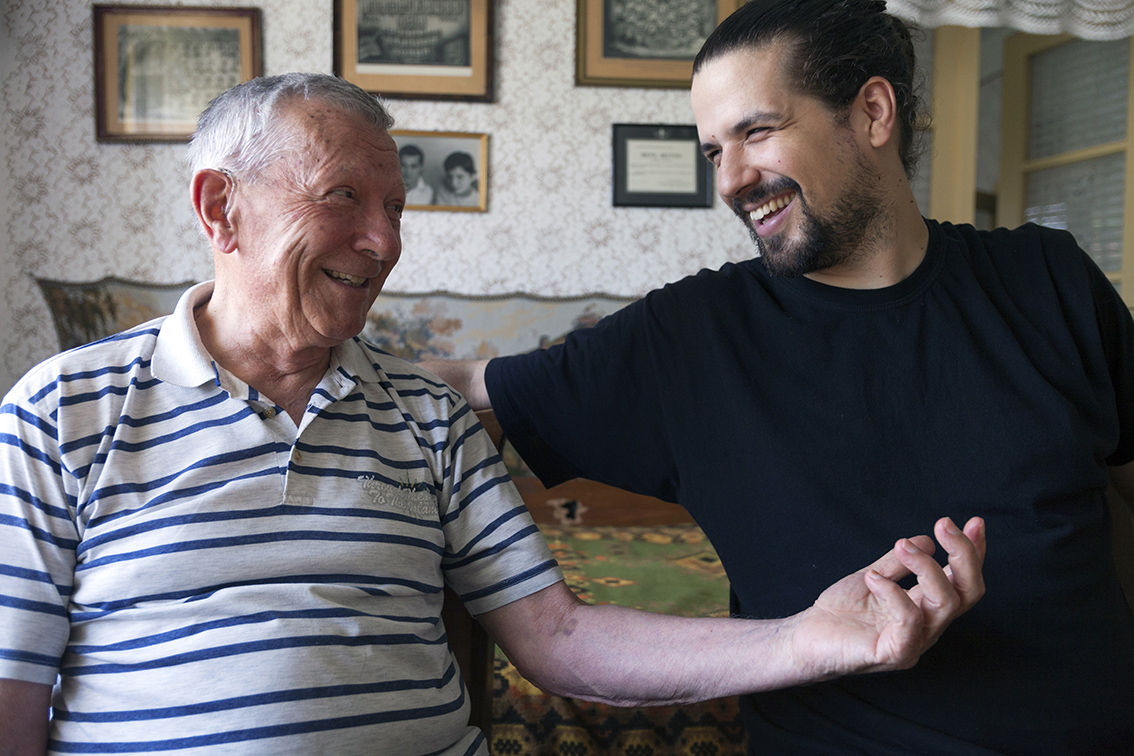 Elderly man laughing with home carer